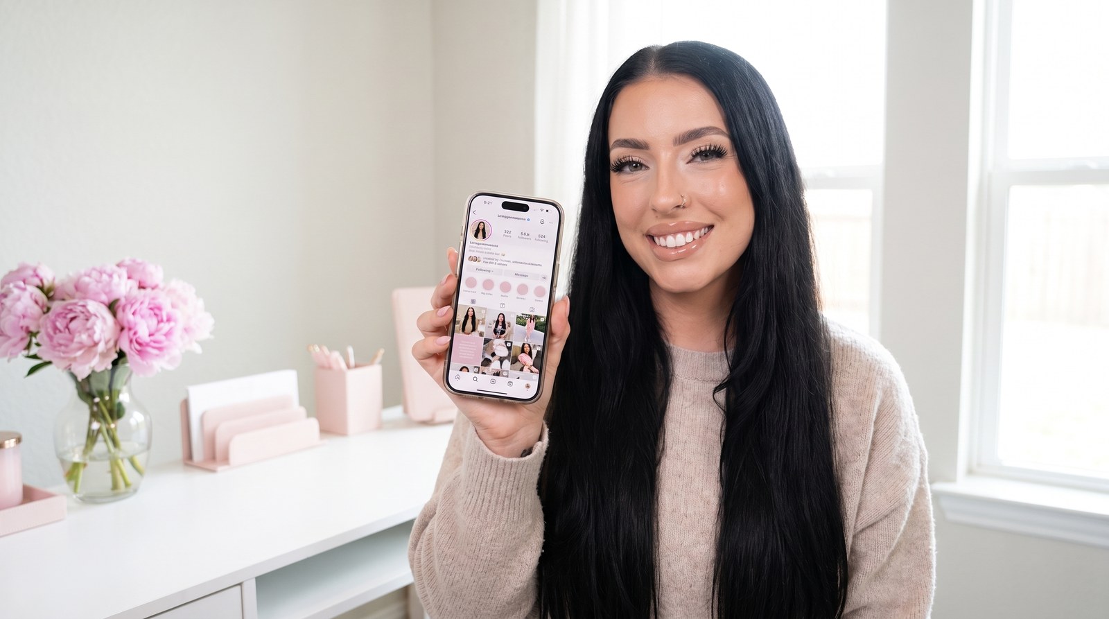 Angie holding up her phone with her Instagram page